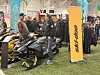 Messehall med Ski-Doo-stand der besøkende ser på snøscootere og scooterdresser.
